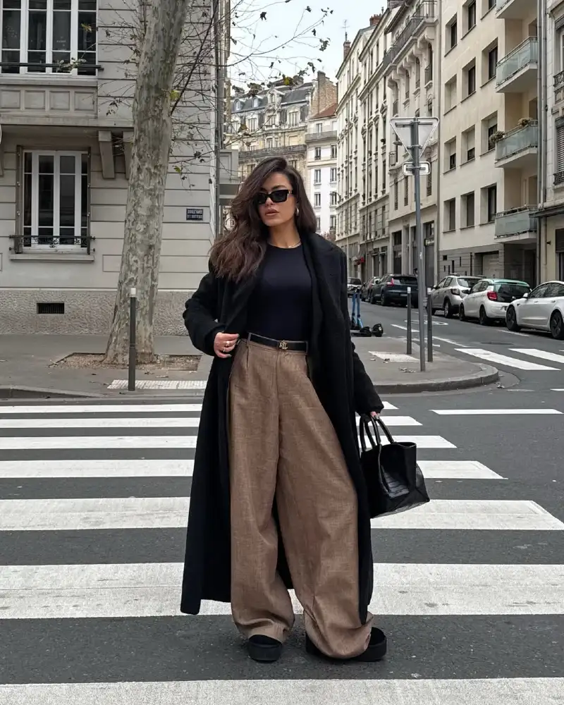 Black Long Coat Over Black Top and Tan Wide Trousers