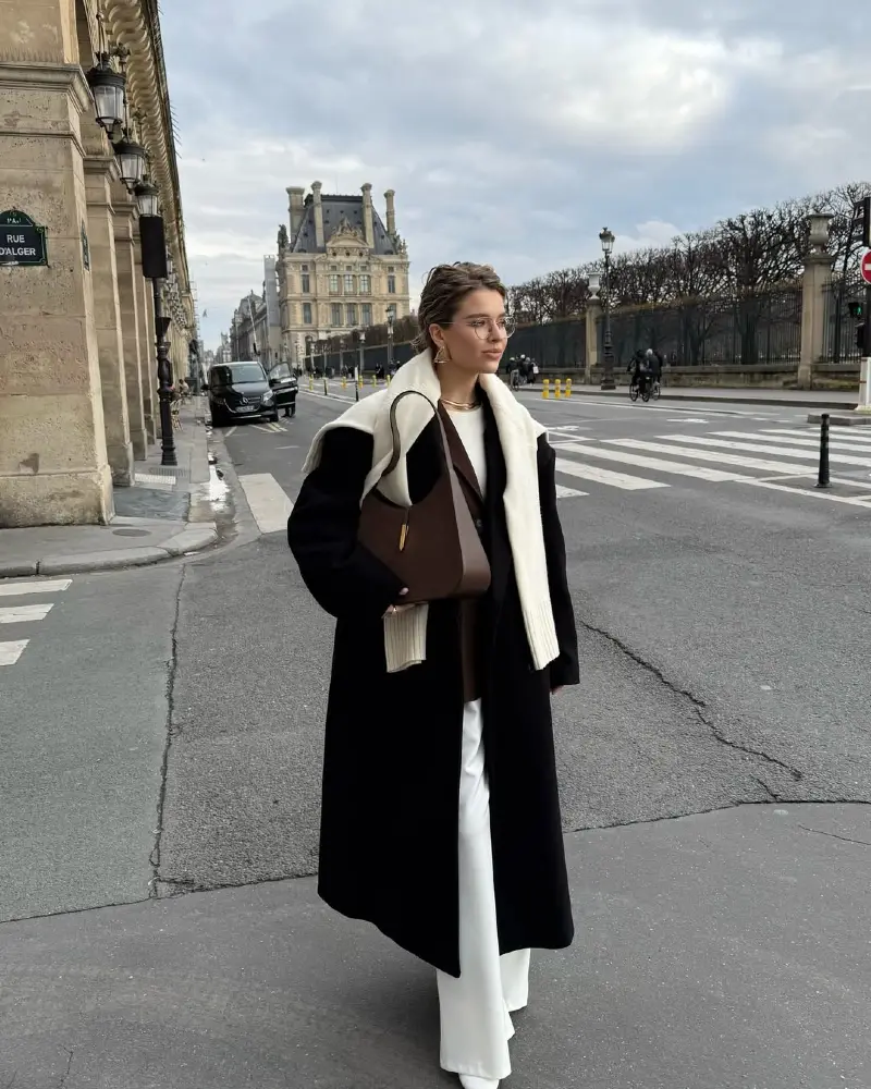 Black Wool Coat With Cream Shearling Collar Over White Trousers
