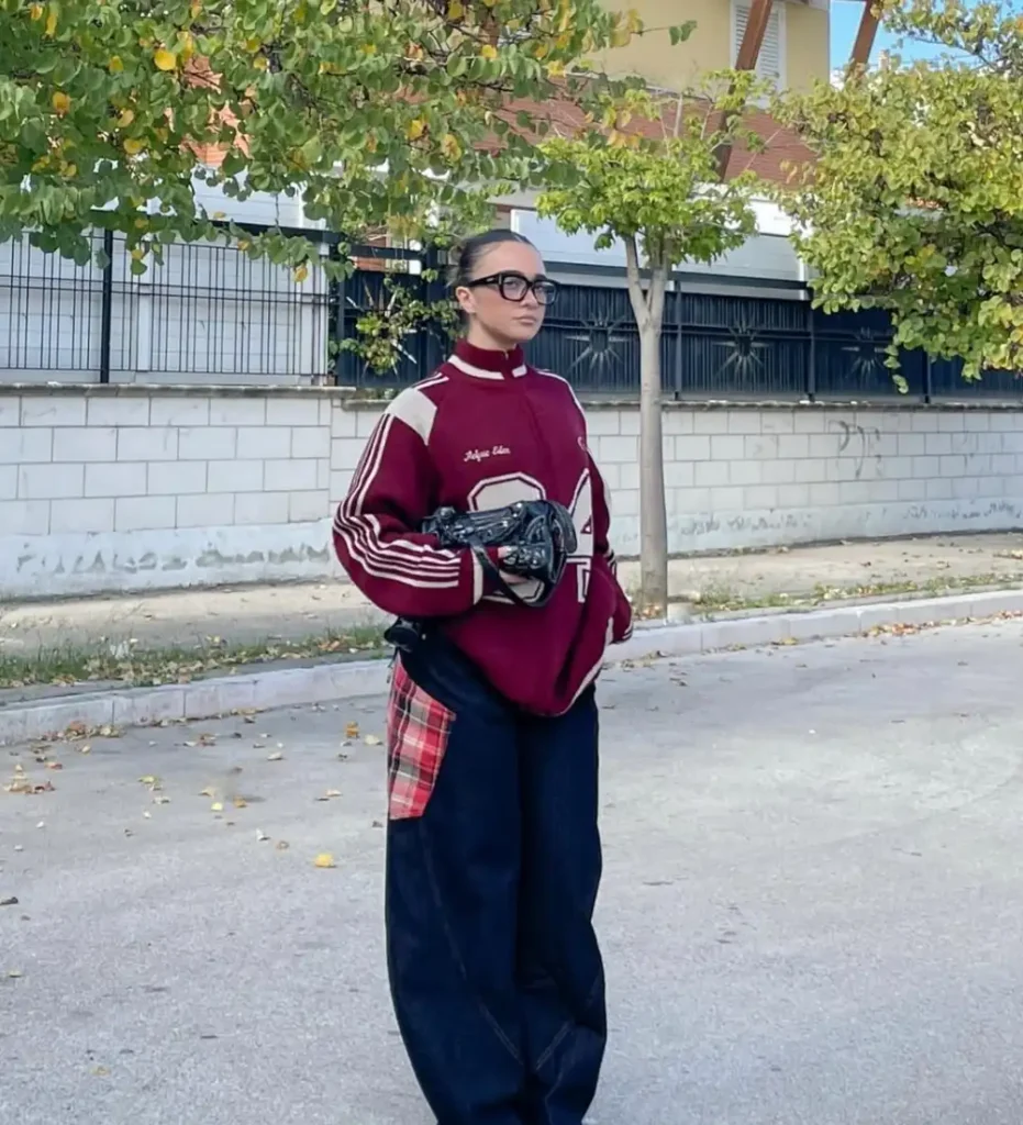 Burgundy Varsity Sweatshirt with Dark Wide-Leg Jeans and Red Pointed Boots