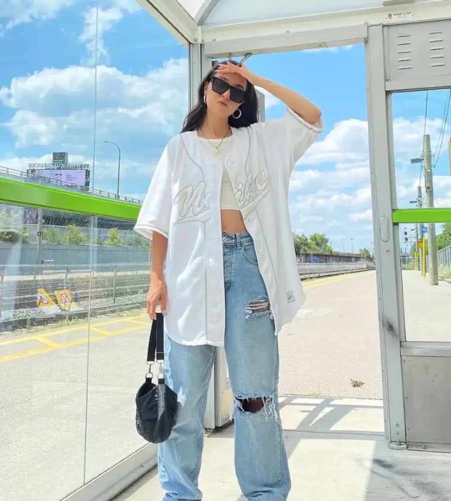 White Baseball Jersey with Ripped Baggy Jeans and White Sneakers