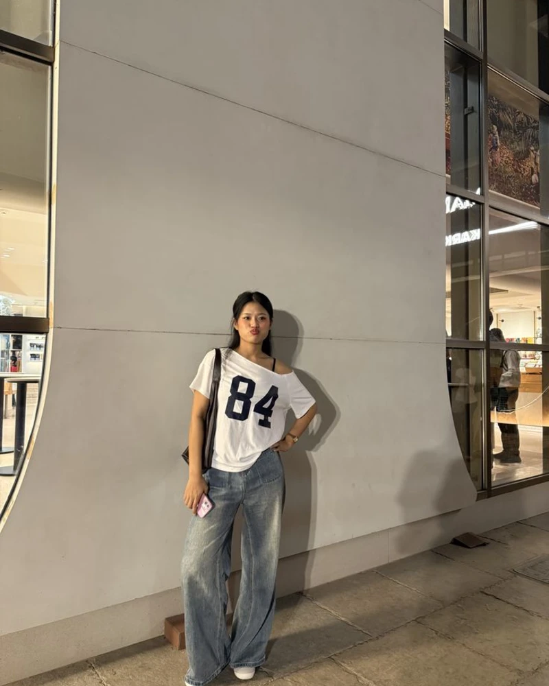 Graphic tee, loose jeans, and a shoulder bag