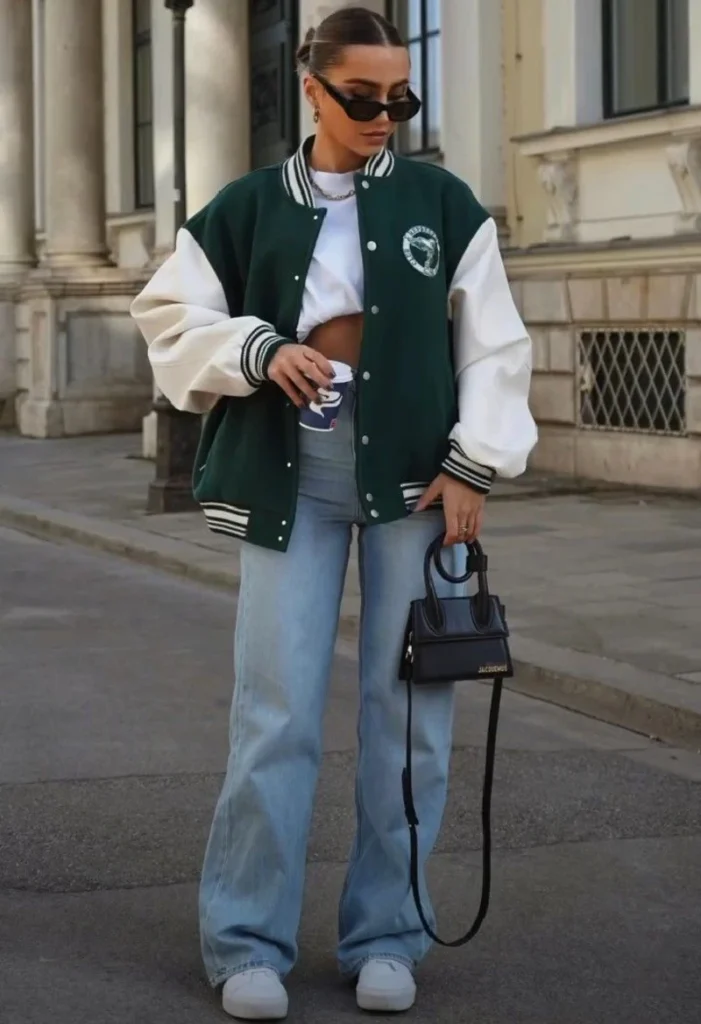 Varsity jacket over a plain tee, straight-leg pants, the same low-top sneakers from combo one