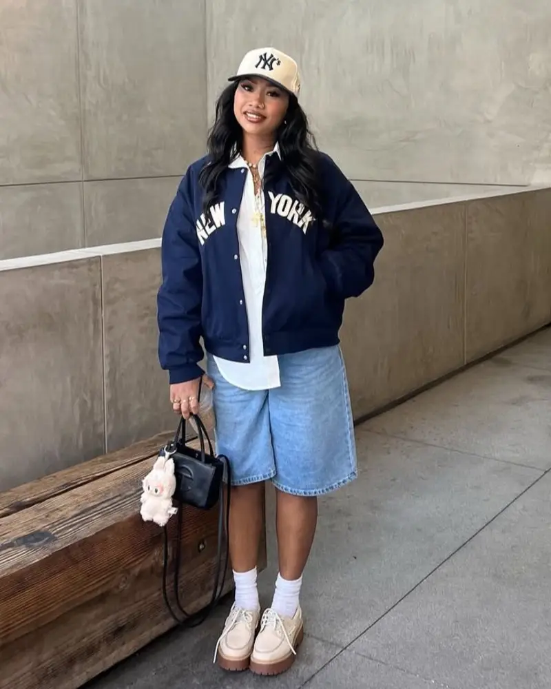 Varsity Jacket With Denim Bermuda Shorts and a Baseball Cap