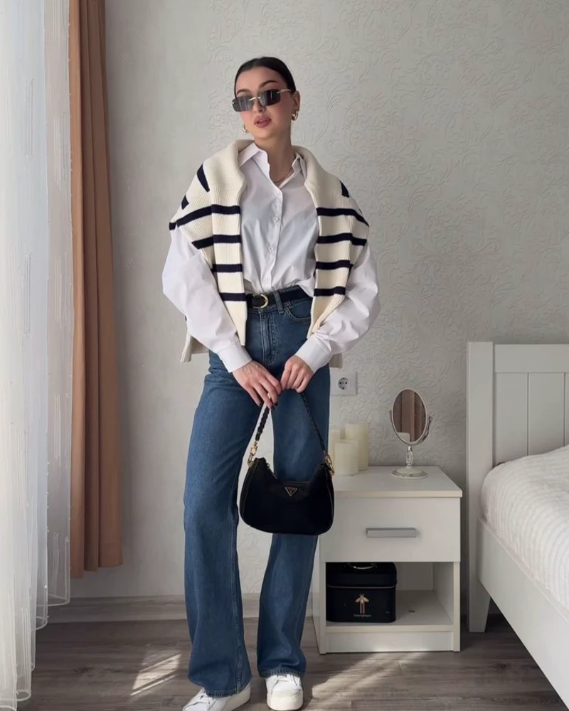 White Shirt With a Striped Sweater Draped Over the Shoulders